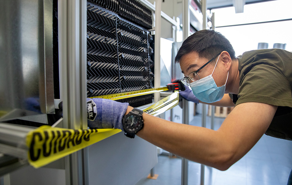 Seunghyeon Jung, a biological systems engineering graduate student, takes measurements while working on a direct air capture (DAC) unit in a lab at the Wisconsin Energy Institute at UW–Madison in Madison, Wis., Friday, Nov. 12, 2021. Jung is part of a team that is one of the top winners in the $5 million XPRIZE for Carbon Removal Student Competition. The team is developing the system, aiming to remove carbon dioxide from the air to mitigate the impacts of climate change. Photo by Michael P. King/UW–Madison CALS